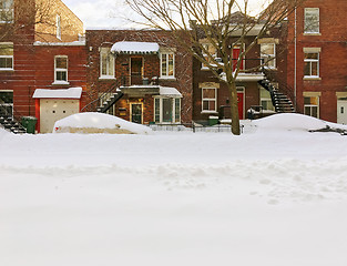 Image showing Snowy urban street with brick buildings