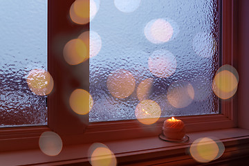 Image showing Cozy frosted window, candle and bokeh lights