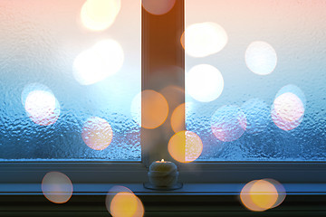 Image showing Frosted window, bokeh lights, and burning candle