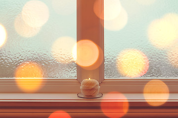 Image showing Cozy candle on a windowsill in golden light