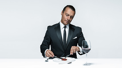 Image showing Bloody Halloween theme: crazy man with a knife, fork and meat