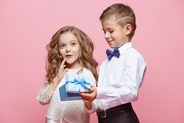 Image showing Boy and girl standing in studio on pink background