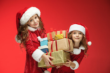 Image showing Two happy girls in santa claus hats with gift boxes