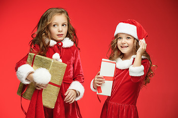 Image showing Two happy girls in santa claus hats with gift boxes