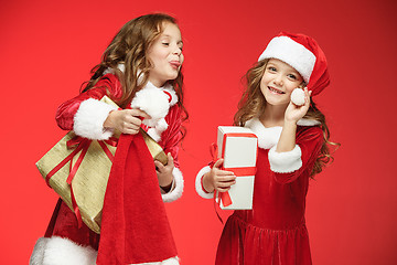 Image showing Two happy girls in santa claus hats with gift boxes