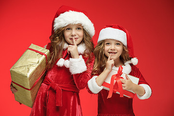 Image showing Two happy girls in santa claus hats with gift boxes