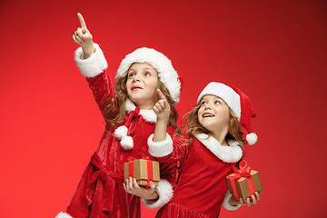 Image showing Two happy girls in santa claus hats with gift boxes