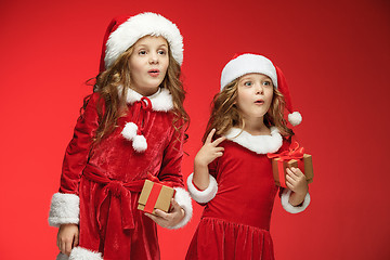 Image showing Two happy girls in santa claus hats with gift boxes