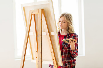 Image showing student girl with easel painting at art school