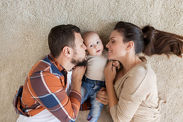 Image showing happy family with baby lying on floor at home