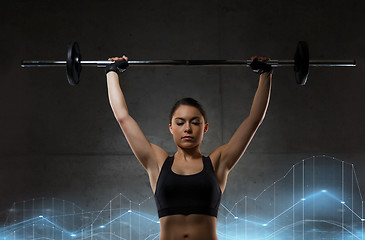 Image showing young woman flexing muscles with barbell in gym