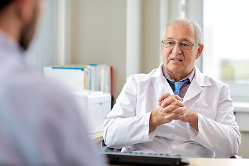 Image showing senior doctor talking to male patient at hospital