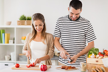 Image showing happy couple cooking food at home kitchen