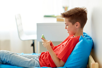 Image showing happy smiling boy with smartphone at home