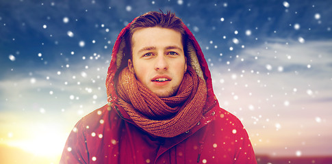 Image showing happy man in winter jacket with hood outdoors