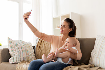 Image showing happy mother with baby boy taking selfie at home