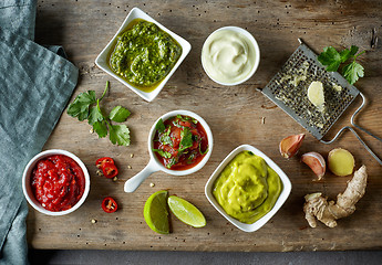 Image showing various sauces on wooden table