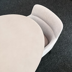 Image showing Round table and comfortable fabric chair