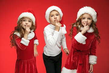 Image showing The happy boy and girls in santa claus hats with gift boxes at studio