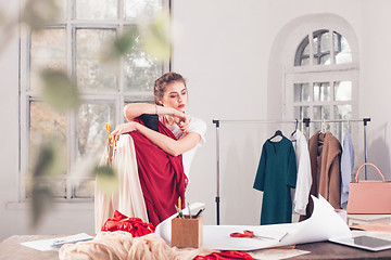 Image showing Fashion designers working in studio sitting on the desk