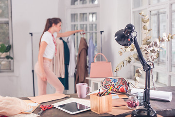 Image showing Fashion designers working in studio sitting on the desk