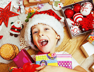 Image showing little cute boy with Christmas gifts at home. close up emotional