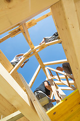 Image showing Builders at work with wooden roof construction.