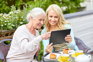 Image showing daughter with tablet pc and senior mother at cafe