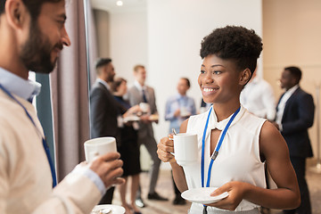 Image showing business people with conference badges and coffee