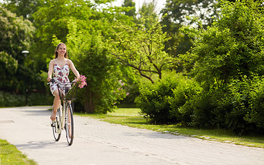 Image showing happy woman riding fixie bicycle in summer park