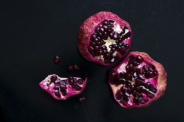 Image showing Two pomegranates on a black scratched background. Top view