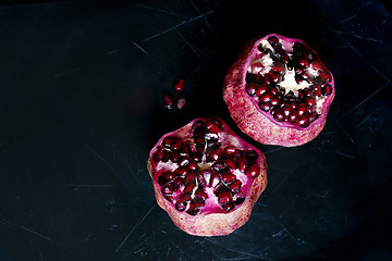 Image showing Two pomegranates on a black scratched background. Top view