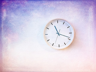 Image showing Modern round clock on painted purple wall