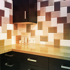 Image showing Kitchen cabinets and tiled backsplash in warm colors