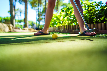 Image showing Mini Golf yellow ball with a bat at sunset