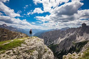 Image showing Hiker woman standing up achieving the top Dolomites Alps.