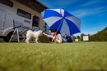 Image showing Woman on the grass with a dog looking at a laptop