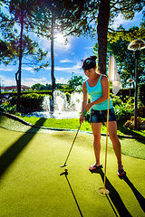 Image showing Mini Golf - Woman playing Golf on green grass at sunset