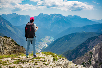 Image showing Hiker woman standing up achieving the top Dolomites Alps.