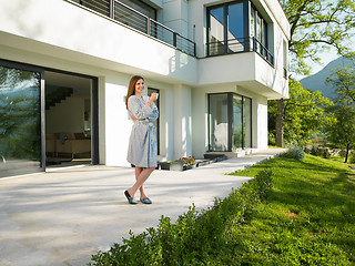 Image showing woman in a bathrobe enjoying morning coffee