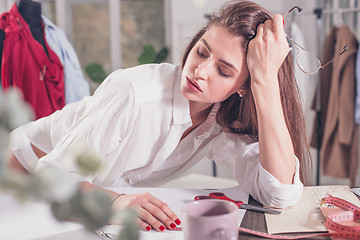 Image showing Fashion designers working in studio sitting on the desk