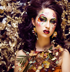 Image showing beauty woman with face art and jewelry from flowers orchids clos