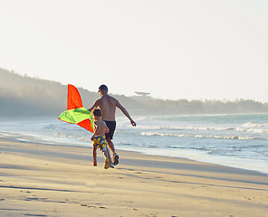 Image showing father with son, sunset at the seacoast with kite, happy family 