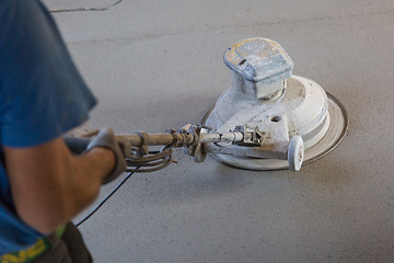 Image showing Laborer polishing sand and cement screed floor.