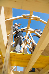 Image showing Builders at work with wooden roof construction.