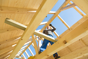 Image showing Builder at work with wooden roof construction.