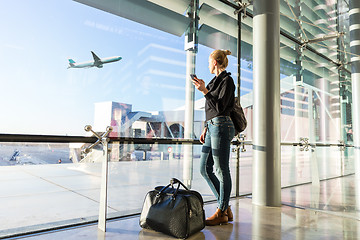 Image showing Young woman waiting at airport, looking through the gate window.