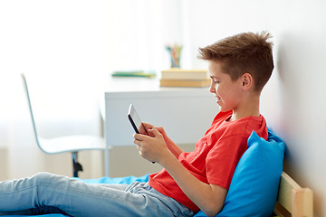 Image showing smiling boy with tablet pc computer at home