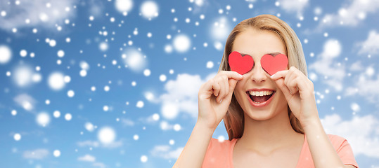 Image showing happy young woman with red heart shapes on eyes