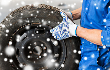 Image showing close up of auto mechanic with car tire